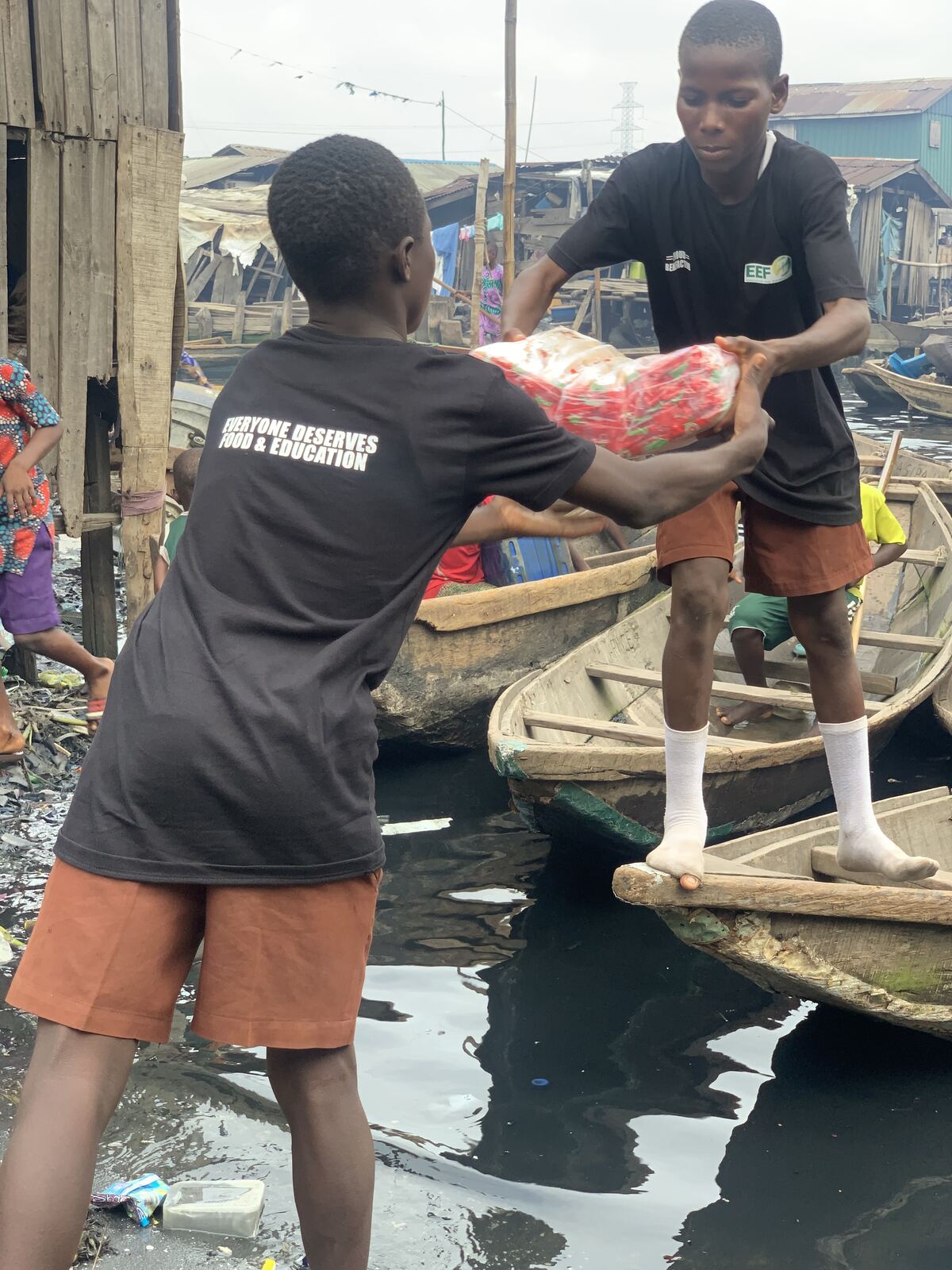 One parcel at a time. Handing food up from the canoes to the families waiting on the walkways.
